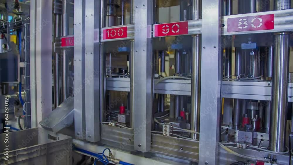 Automatic machinery pressed down on the items on a conveyor belt. Automatic machinery pressed down on the items on a conveyor belt.