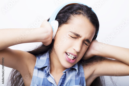 Afro-American little girl with headphones listening to music on white background