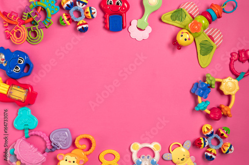 Children's rattle from plastic on a pink background. Top view