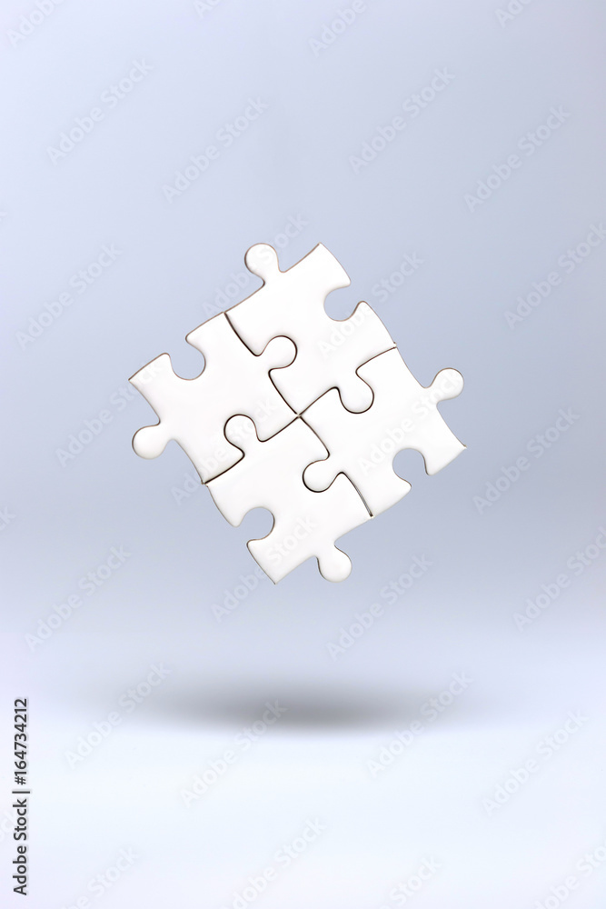 Connected blank puzzle pieces floating in the air. Business teamwork concept.