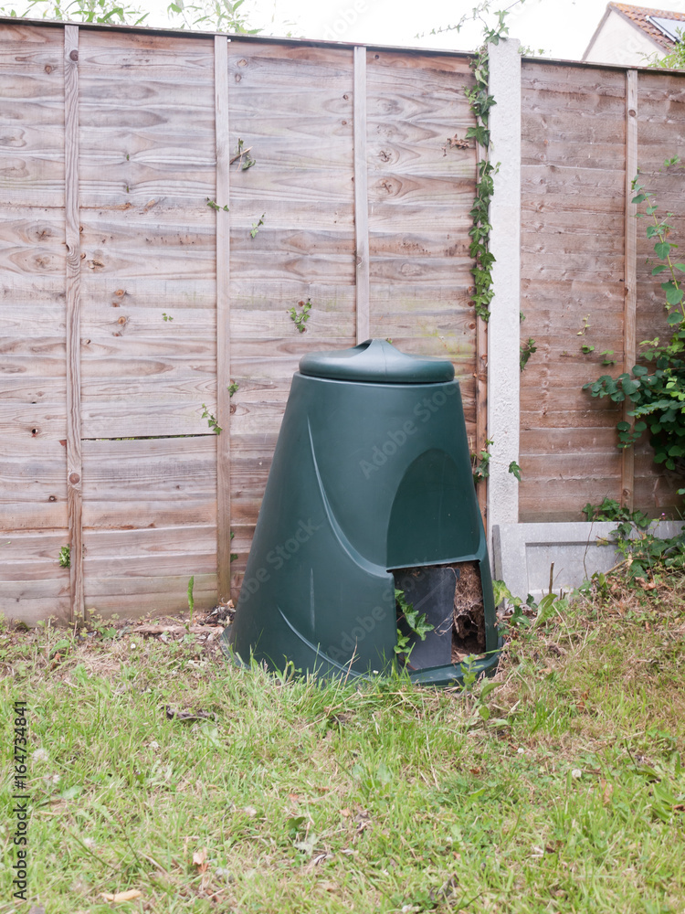 a green compost bin outside in garden a green compost bin outside in garden