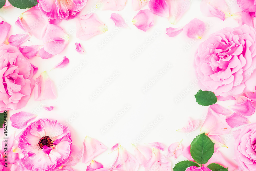 Round frame made of pink flowers, petals and leaves on white background. Floral lifestyle composition. Flat lay, top view.