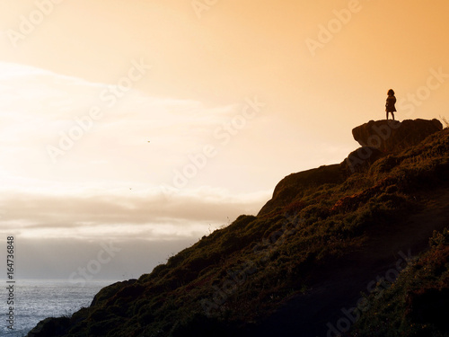 Woman looking the sea in the sunset