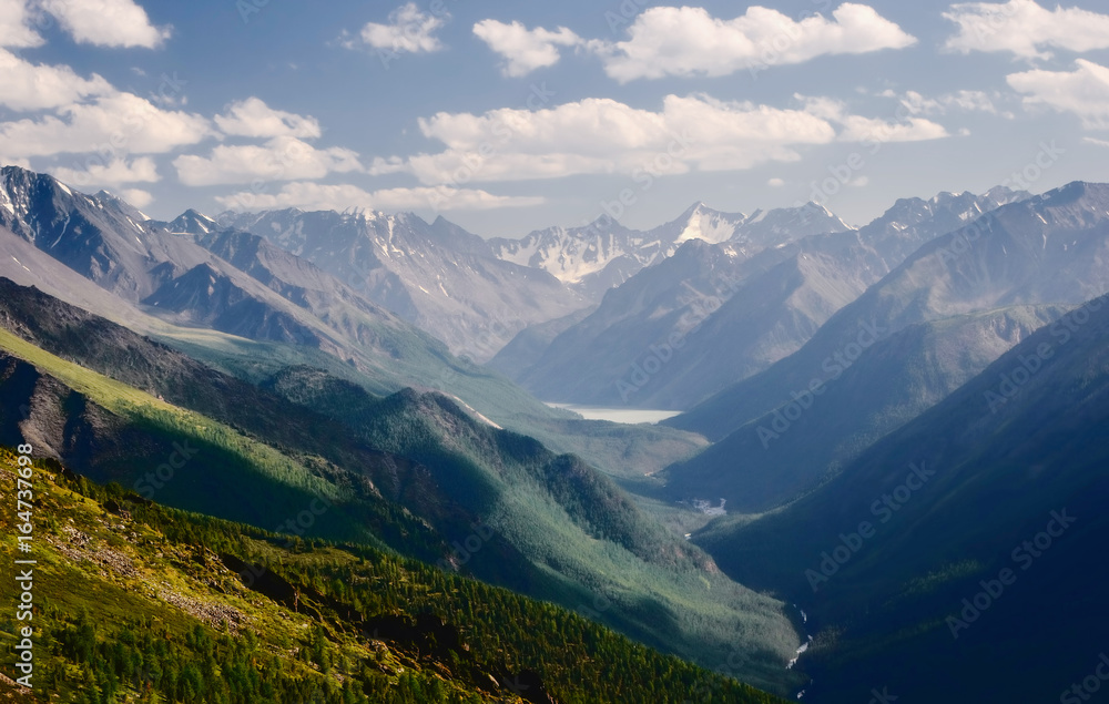 Mountain bright high key valley with a river and lake on the background of glaciers and snow peaks with high, steep slopes  view from above Kucherla Altai Mountains Siberia, Russia