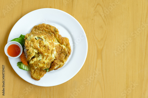Thai Omelet  with jusmine steamed rice on wood table background