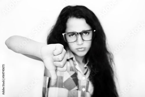 Portrait of unhappy teenage girl showing  sign of unlike or bad. Studio shot