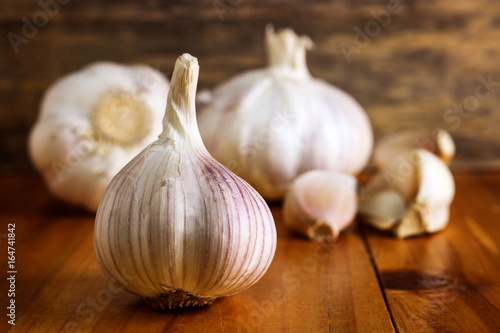 Garlic clove and garlic bulb on wooden background