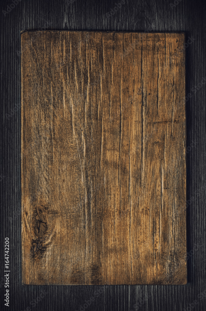 Obraz premium Old wooden board on a dark wooden background