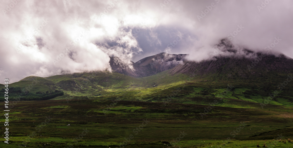 Green hills wrapped in mist in the Isle of Skye. Scottish Highlands, UK