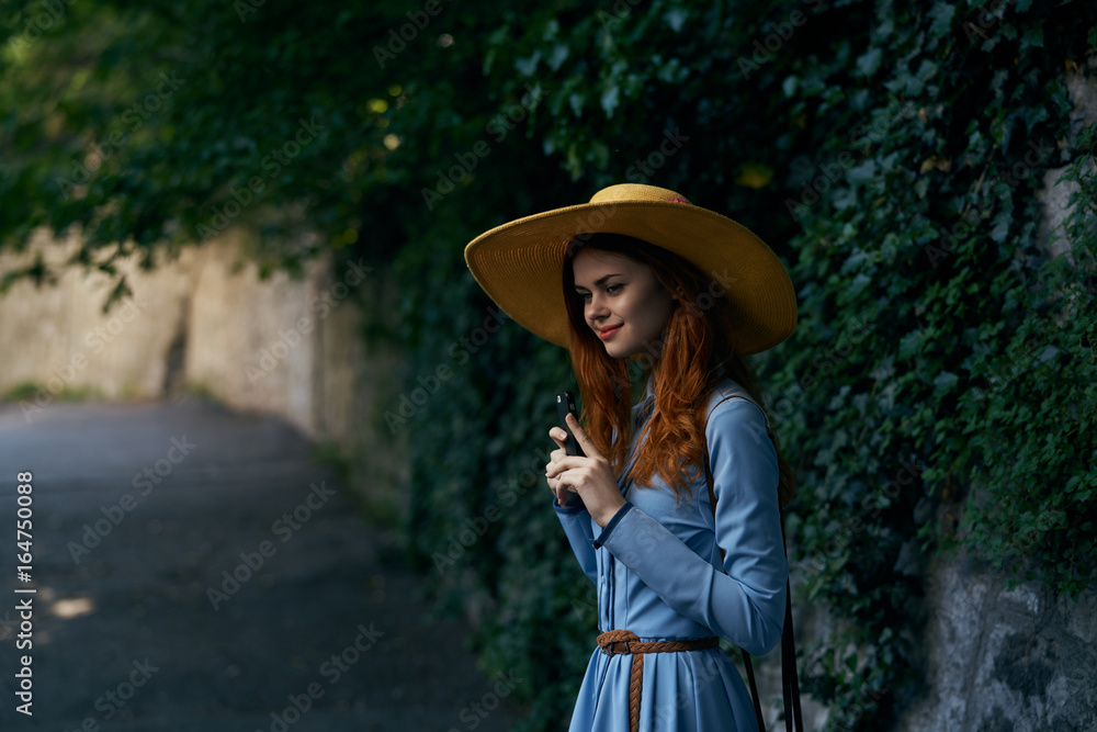 Young beautiful woman in blue dress walking with her camera around the city