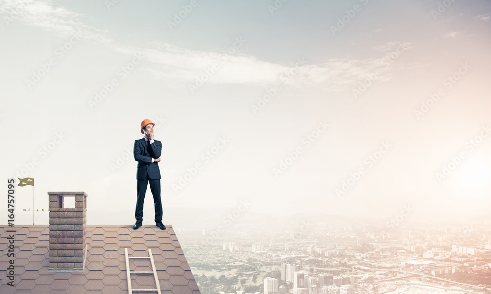 Engineer man standing on roof and looking away. Mixed media Engineer man standing on roof and looking away. Mixed media