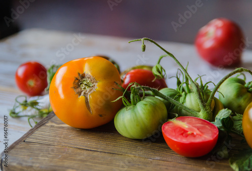 Colorful ripe red, yellow, orange and green tomatoes. Vintage wooden background