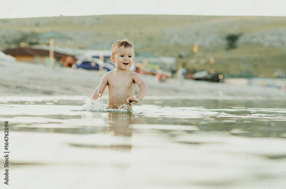 Happy baby playing in the sea Happy baby playing in the sea