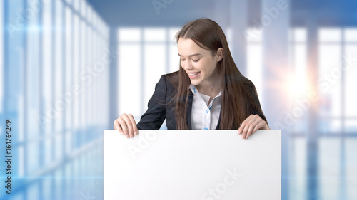 Young beautiful business woman and creative designer standing over blured interior background