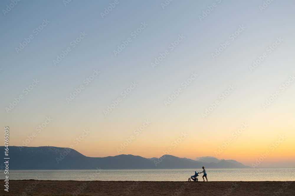 Silhouette of mother with stroller enjoying motherhood at sunset landscape Silhouette of mother with stroller enjoying motherhood at sunset landscape