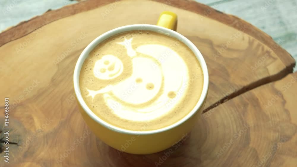 Coffee cup with snowman art. Latte on wooden surface. Coffee cup with snowman art. Latte on wooden surface.
