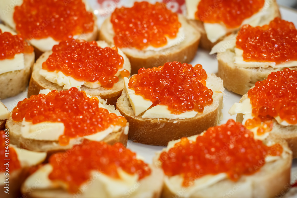 Many small sandwiches with red caviar