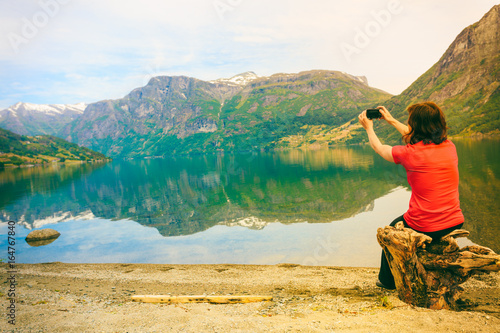 Tourist taking photo at norwegian fjord photo