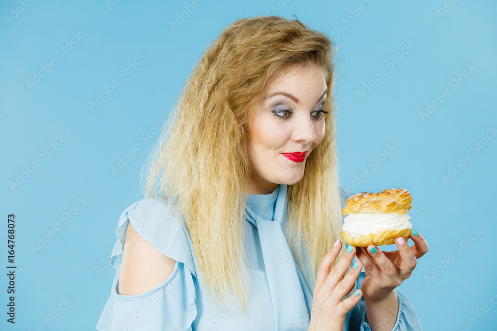 Funny woman holds cream puff cake