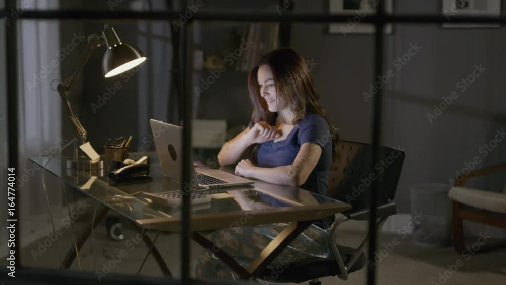 Medium high angle view of woman using laptop at desk then leaving / Cedar Hills, Utah, United States