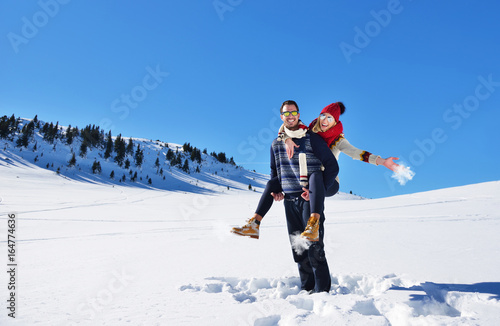 Loving couple playing together in snow outdoor.