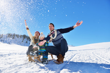happy young family playing in fresh snow at beautiful sunny winter day outdoor in nature