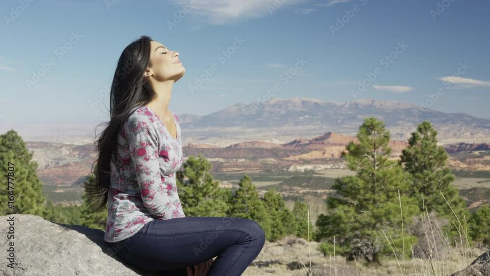 Medium zoom in shot of woman relaxing in desert / Boulder, Utah, United States Medium zoom in shot of woman relaxing in desert / Boulder, Utah, United States