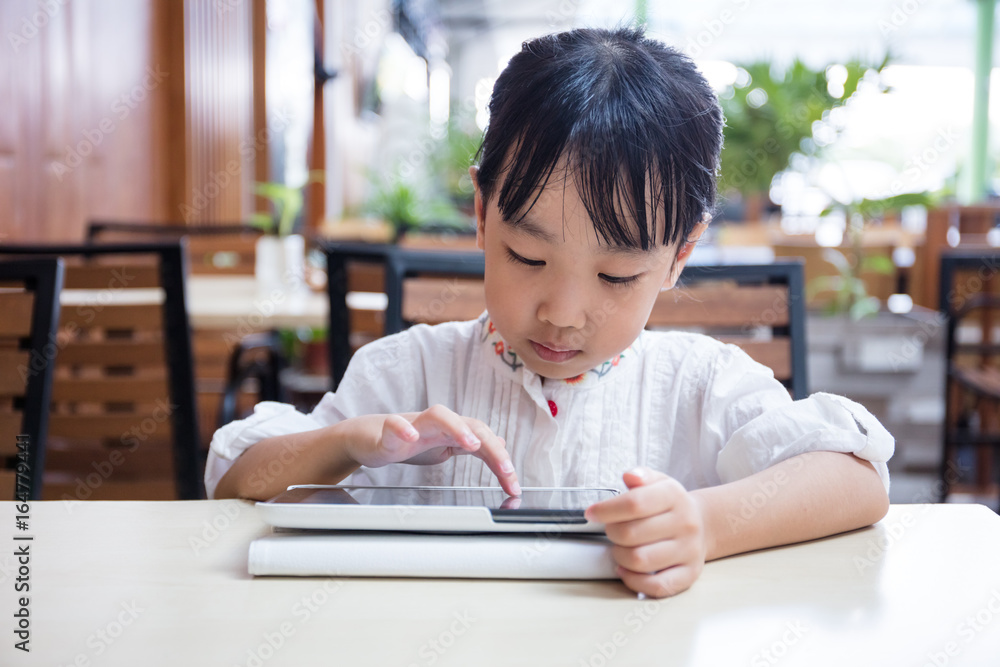 Asian Chinese little girl playing tablet computer Asian Chinese little girl playing tablet computer