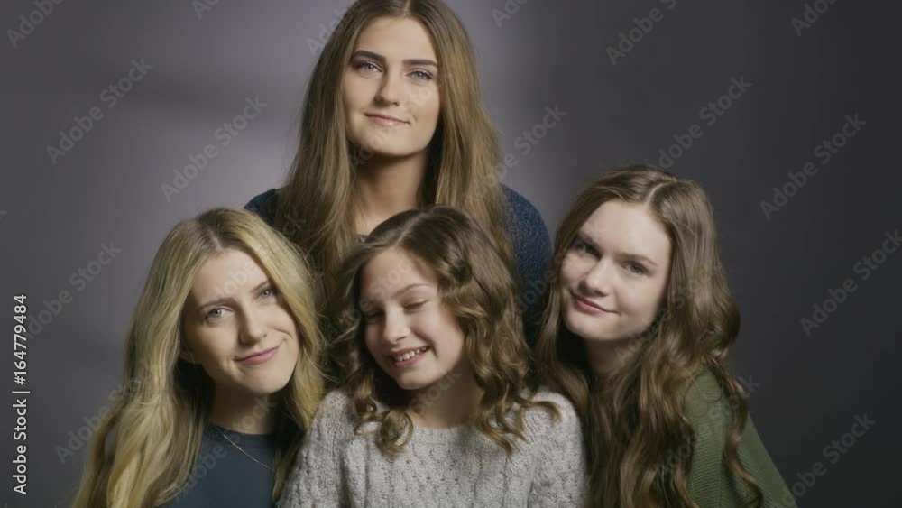 Close up shot of portrait of four sisters smiling together in studio / Cedar Hills, Utah, United States Close up shot of portrait of four sisters smiling together in studio / Cedar Hills, Utah, United States
