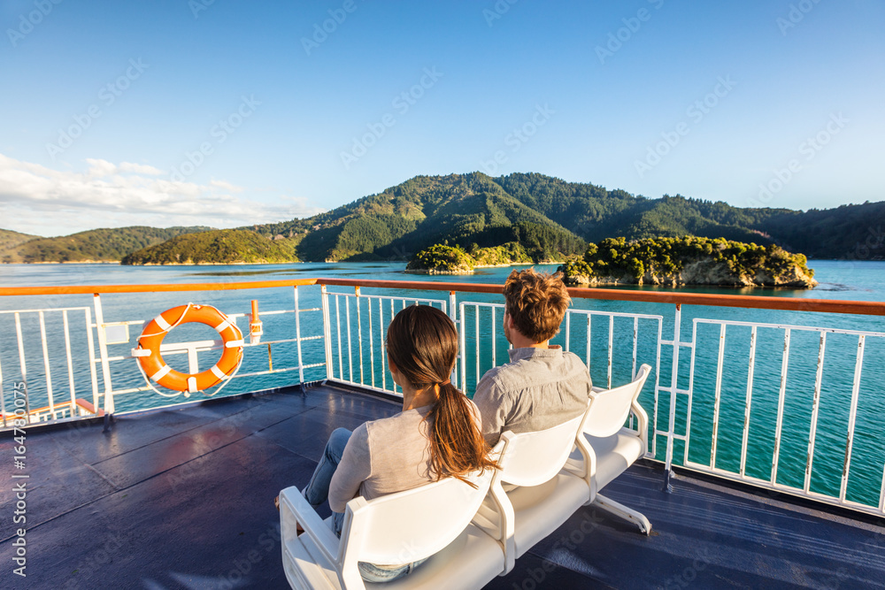 New Zealand cruise travel passengers enjoying nature view of ferry boat cruising in Marlborough sounds trip from Picton to Wellington, Cook strait. Couple tourists sitting outside on deck. - obrazy, fototapety, plakaty 