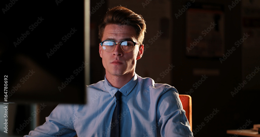 man working on computer in dark office man working on computer in dark office