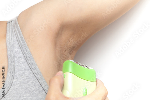 Obraz na płótnie Woman's using hair remover to remove armpit's hairy on white background isolated w salonie