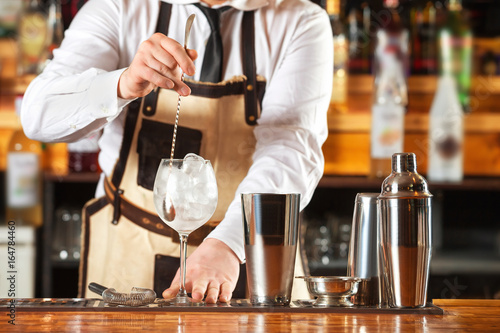 Wallpaper Mural Bartender is mixing cocktail with spoon at bar counter background. Torontodigital.ca