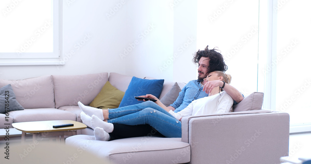 Young couple on the sofa watching television Young couple on the sofa watching television