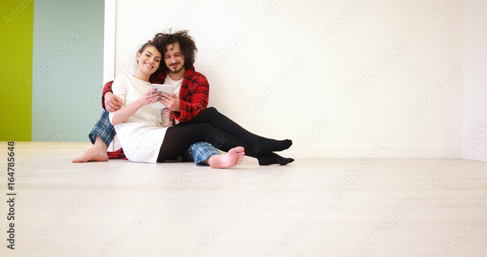 Young Couple using digital tablet on the floor Young Couple using digital tablet on the floor
