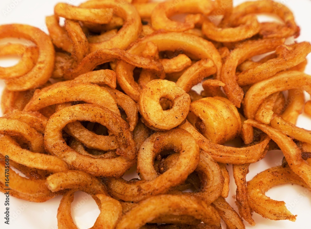 Crispy baked curly fries on a white background
Crispy baked curly fries on a white background