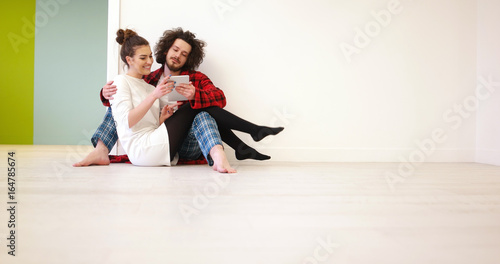 Young Couple using digital tablet on the floor
