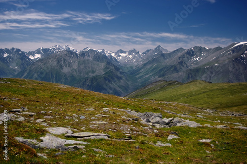 Fototapeta Naklejka Na Ścianę i Meble -  Mountain valley on the background of ranges and snow peaks view from above top height with rocks and alpine meadow in the foreground  Altai Mountains Siberia, Russia
