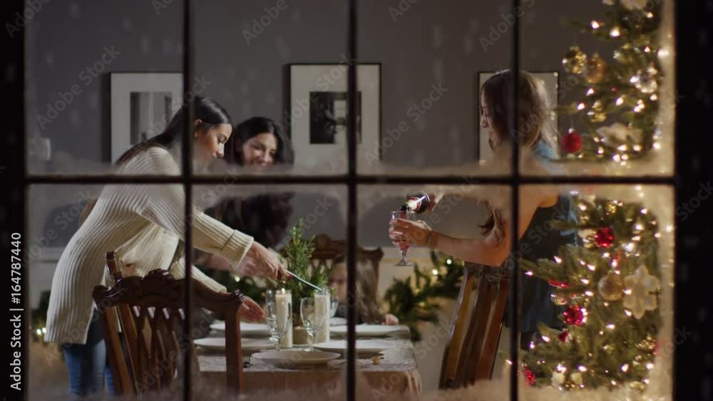Medium zoom in shot of women setting the table on Christmas behind window / Cedar Hills, Utah, United States Medium zoom in shot of women setting the table on Christmas behind window / Cedar Hills, Utah, United States