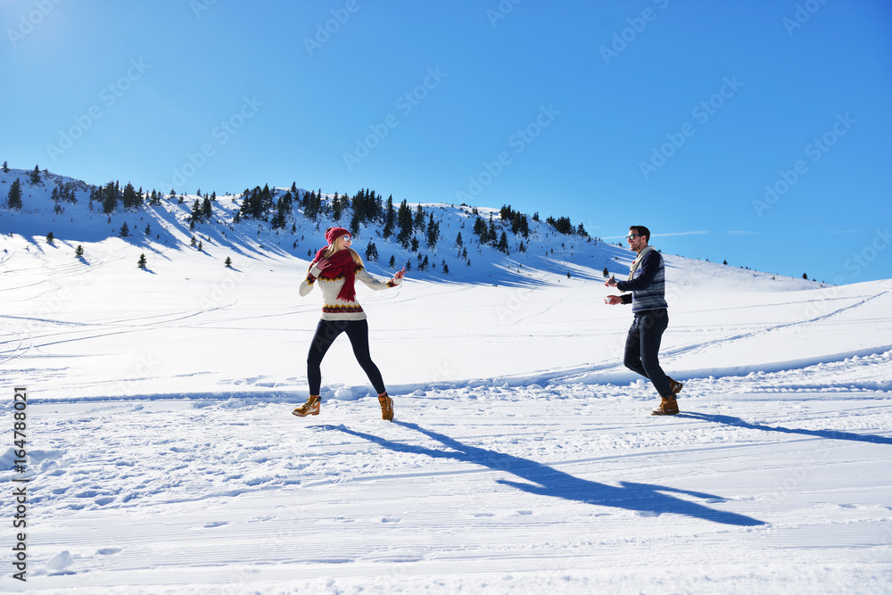 Cheerful young couple having fun in winter park