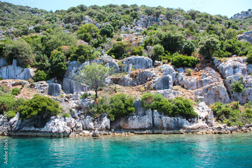 Coast of the island in the Mediterranean sea, picturesque with the ruins of ancient Lycian towns and tombs-sarcophagi of Aperlai, Simena Teimussa Dolihiste. Kekova, Turkey
 photo