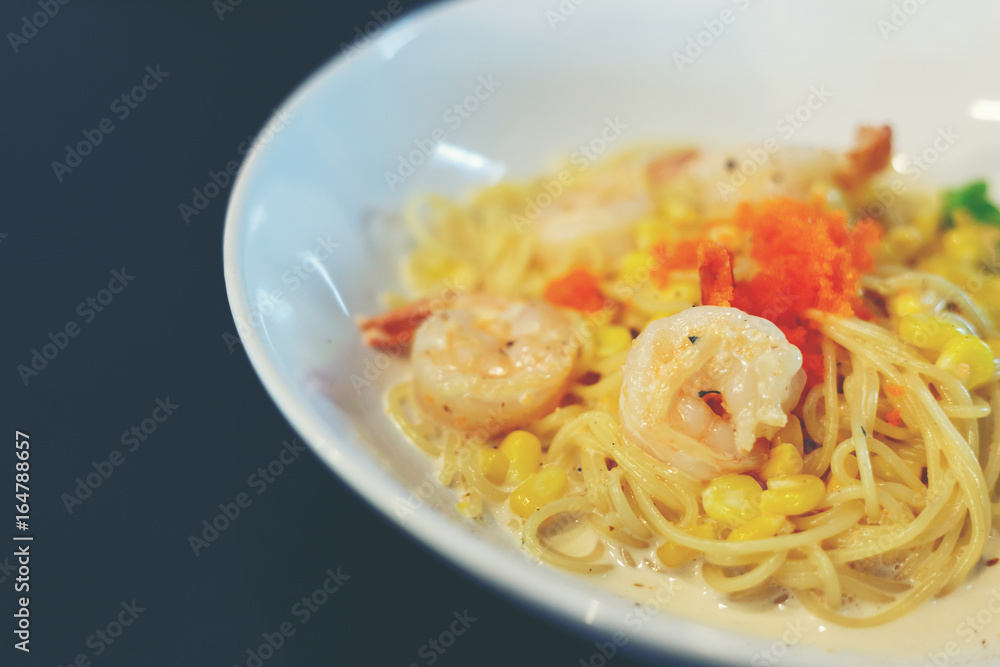 Carbonara spaghetti cream with shrimp in white dish put on black table. Carbonara spaghetti cream with shrimp in white dish put on black table.