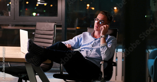 businessman sitting with legs on desk at office