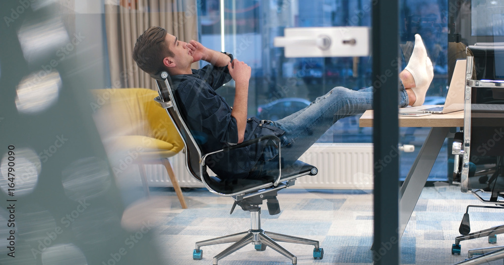 businessman sitting with legs on desk businessman sitting with legs on desk