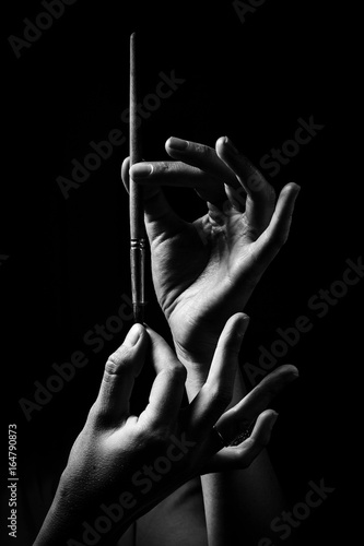 The artist's hands hold a brush