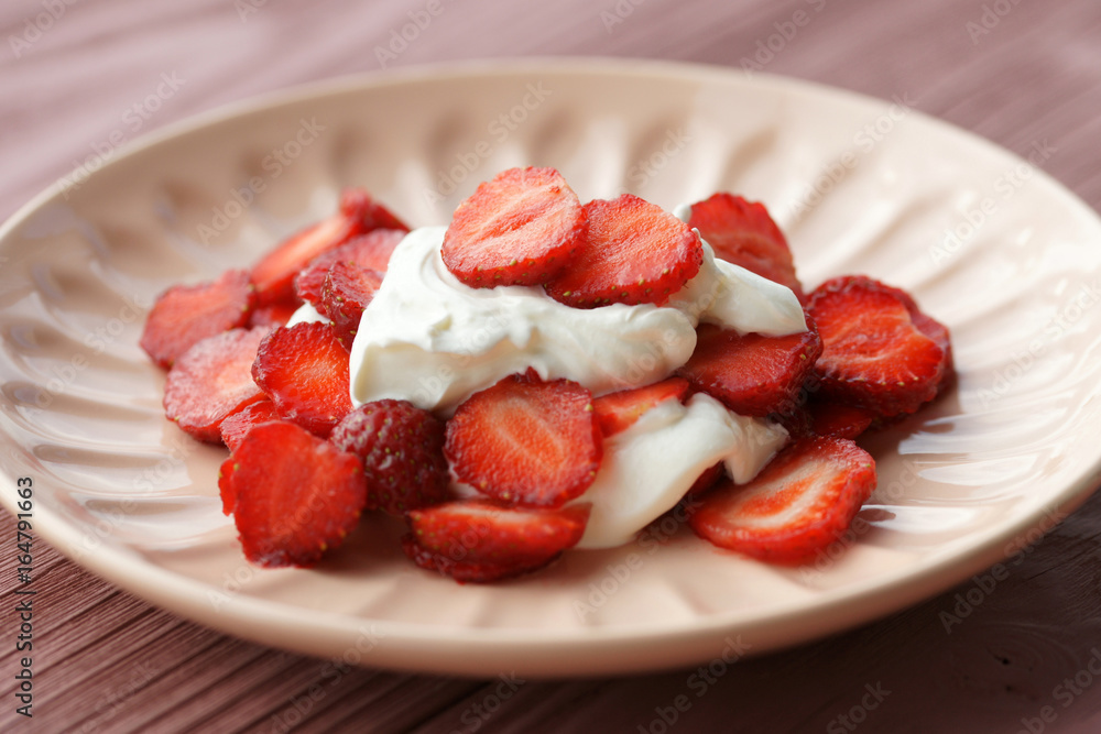 Sliced strawberries with sour cream on a plate Sliced strawberries with sour cream on a plate