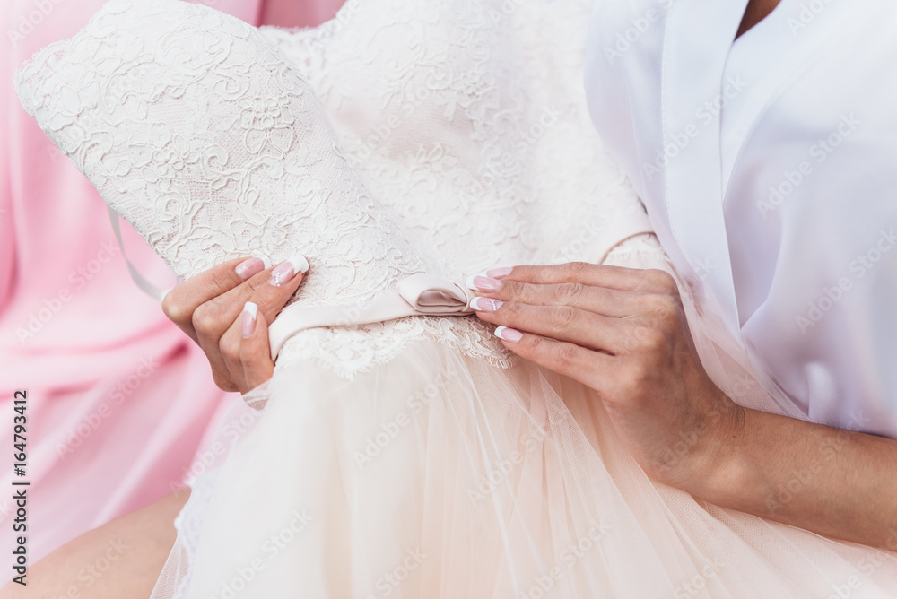 The bride looks at the wedding dress