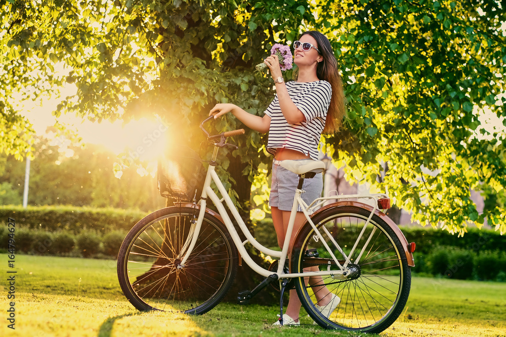 Obraz premium Female holds bouquet near city bicycle.