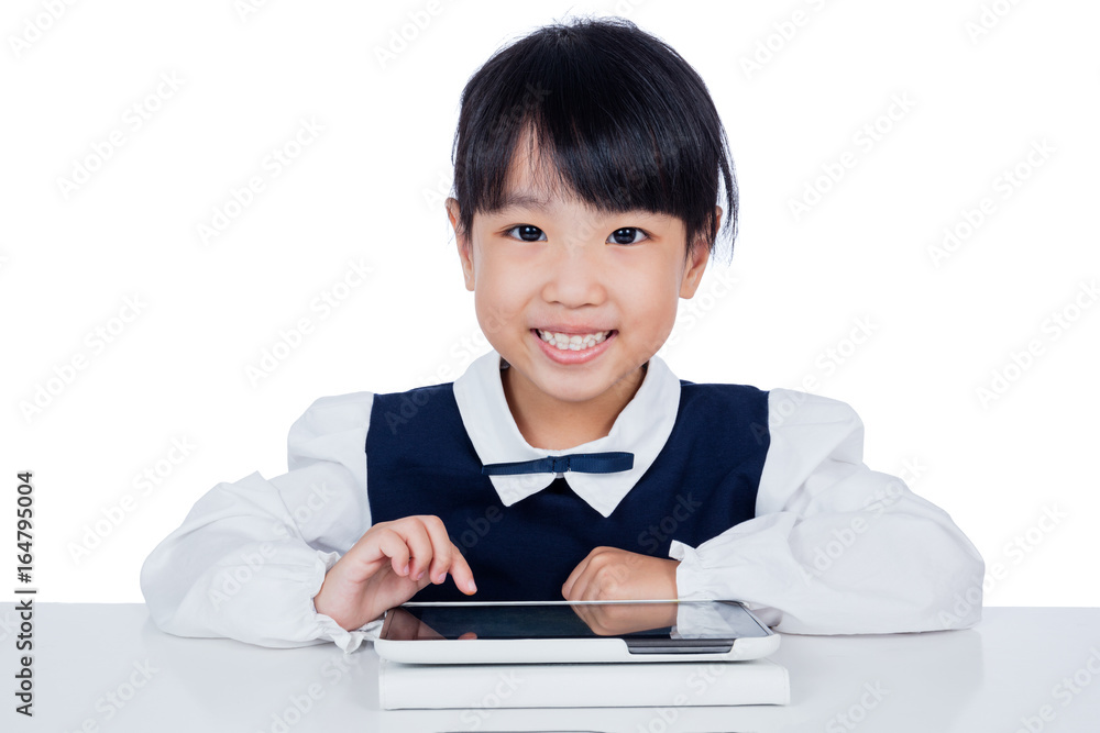 Asian Chinese little girl in uniform playing with tablet computer Asian Chinese little girl in uniform playing with tablet computer