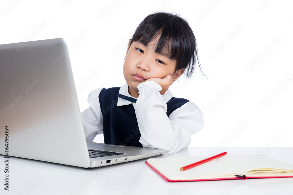 Asian Chinese little girl in uniform studying with laptop Asian Chinese little girl in uniform studying with laptop